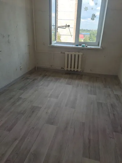 Комната с уложенным линолеумом под доску, стены под чистовую отделку
